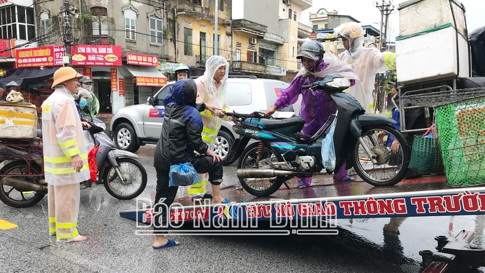 Lực lượng Công an hỗ trợ nhân dân di chuyển qua điểm mưa ngập