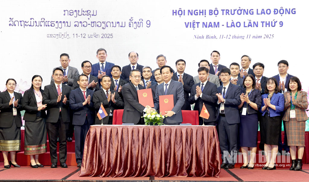 The signing ceremony of the MoU on cooperation in the areas of labour and revolution contributors between the Vietnamese Ministry of Home Affairs and Lao Ministry of Labour and Social Welfare.