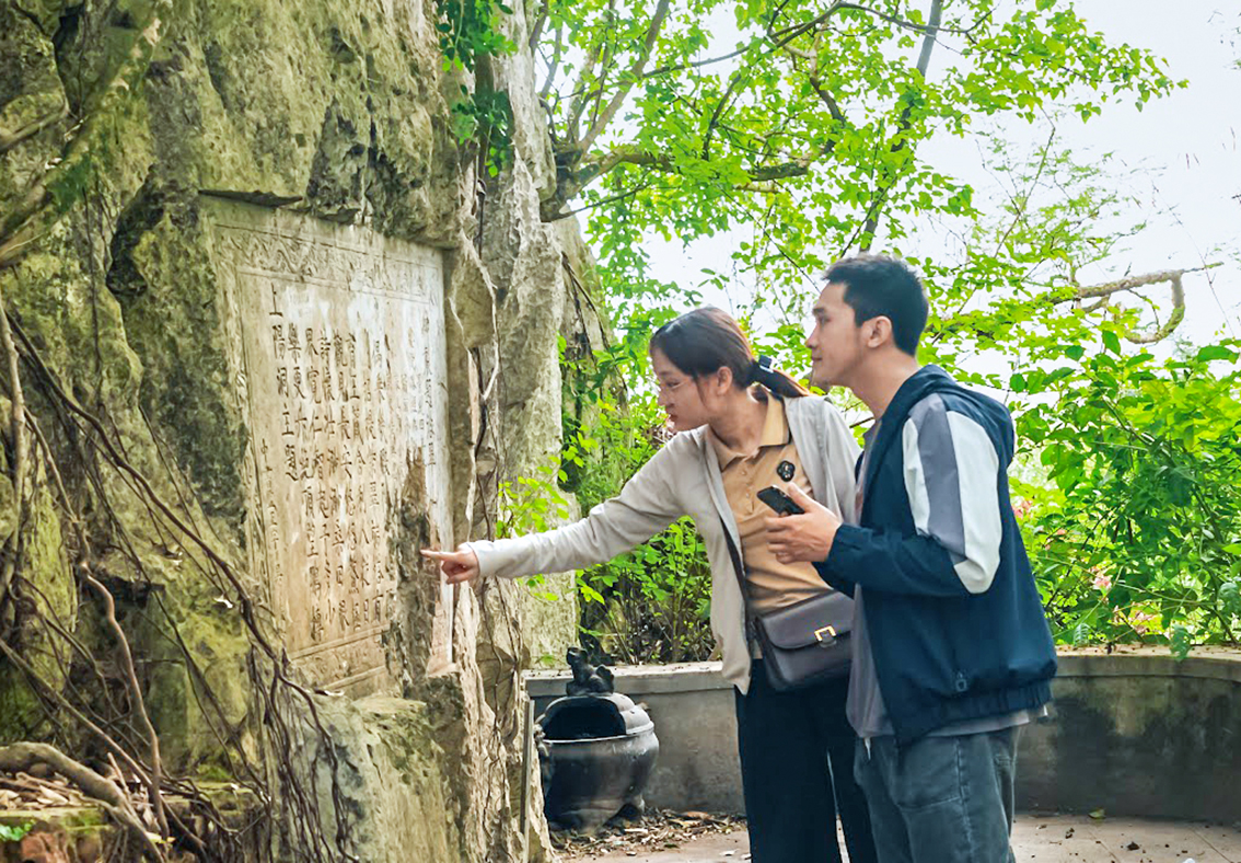 Young people discover stone inscriptions at Non Nuoc's cliffs.