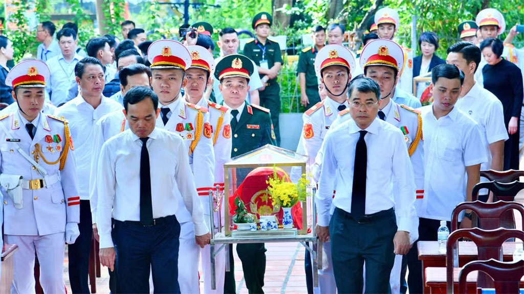 Prime Minister Le Minh Hung carries the remains of a fallen soldier from Le Thi Rieng Park to the designated reburial site. (Photo: VNA)