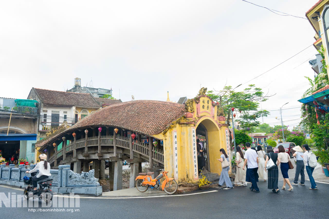 Visitors visit The tile-roof bridge of Luong Pagoda in Hai Anh Commune.