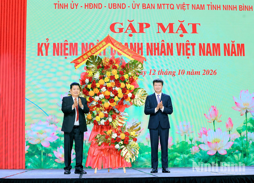 Tran Huy Tuan, Member of the Party Central Committee and Secretary of the Ninh Binh Provincial Party Committee presents flower to congratulate business community.